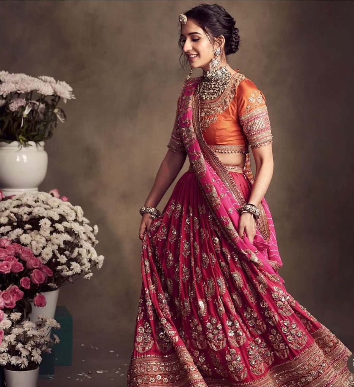 Radhika Merchant made a stunning appearance, dressed in a pink lehenga adorned with heavy gold embroidery and gota patti work. She paired it with an orange choli featuring stone and sequin embellishments. (Pc: instagram)